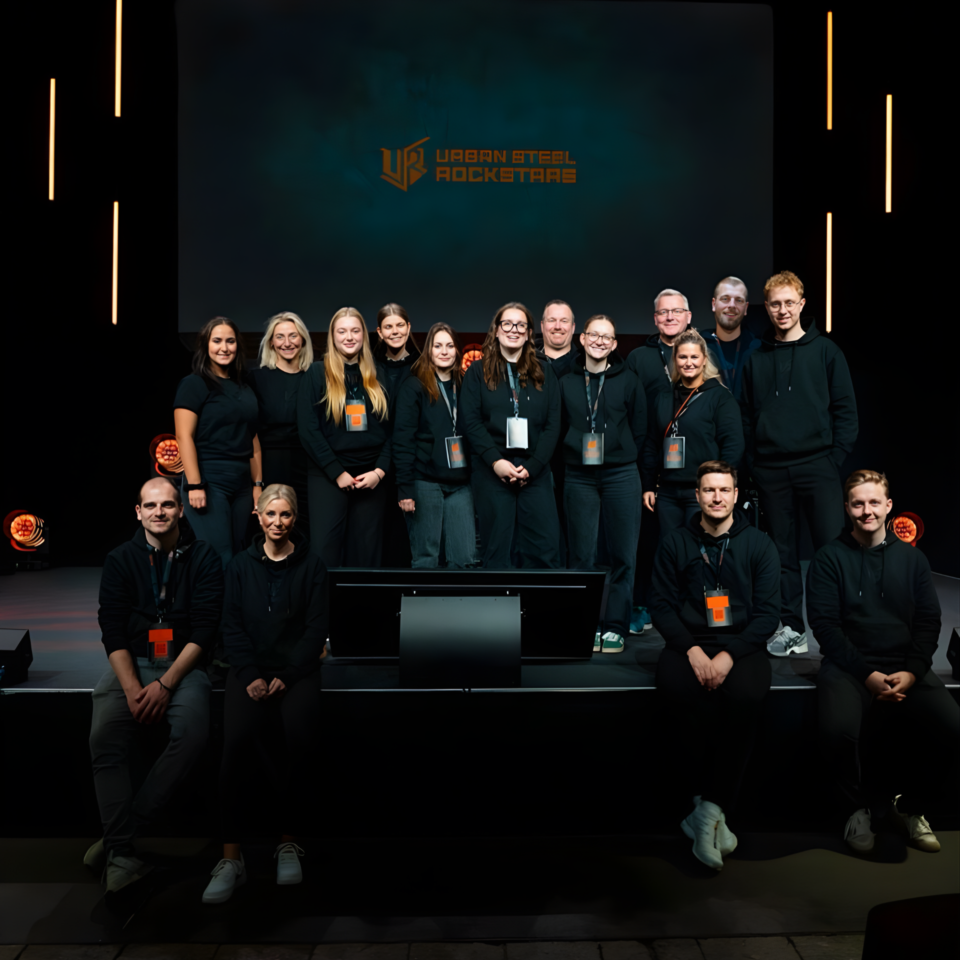 Group photo of the KEMPER team on stage in front of the “Urban Steel Rockstars” display