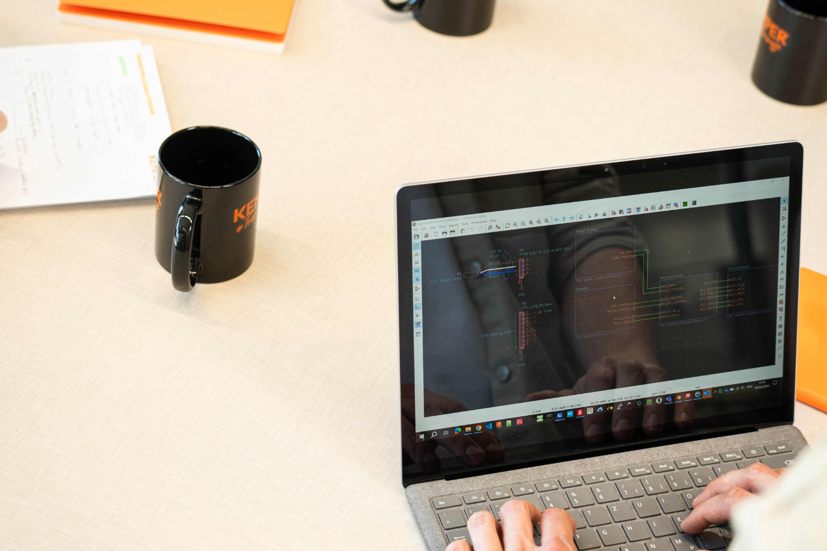 Engineer working on a laptop displaying an electronic circuit diagram for industrial extraction and filtration systems.