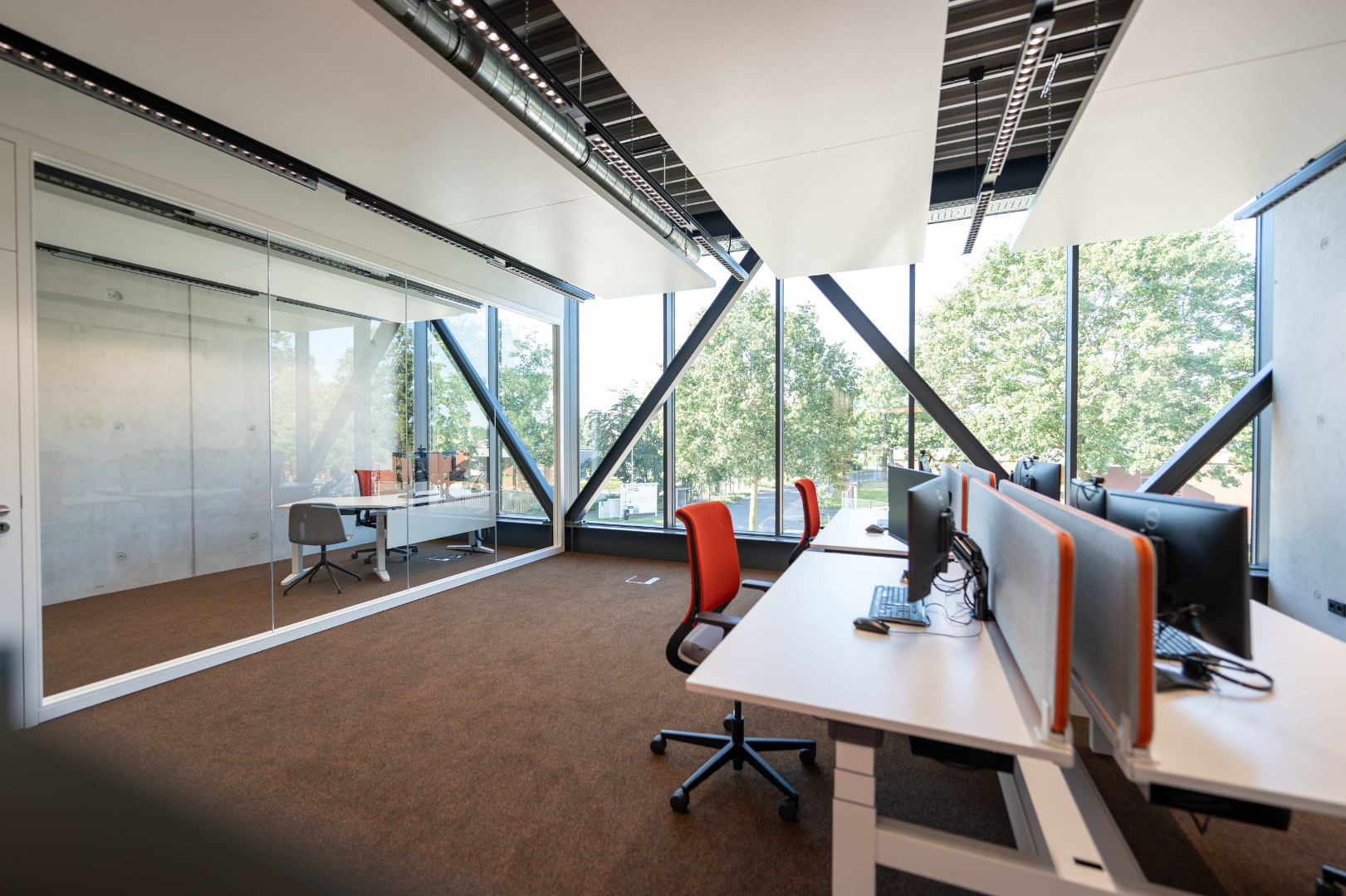 Bright modern office with workstations, computers and meeting room at KEMPER