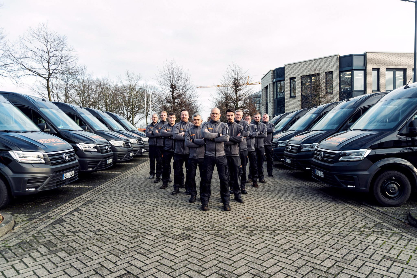 KEMPER service technicians standing in front of their vehicles representing expertise and readiness