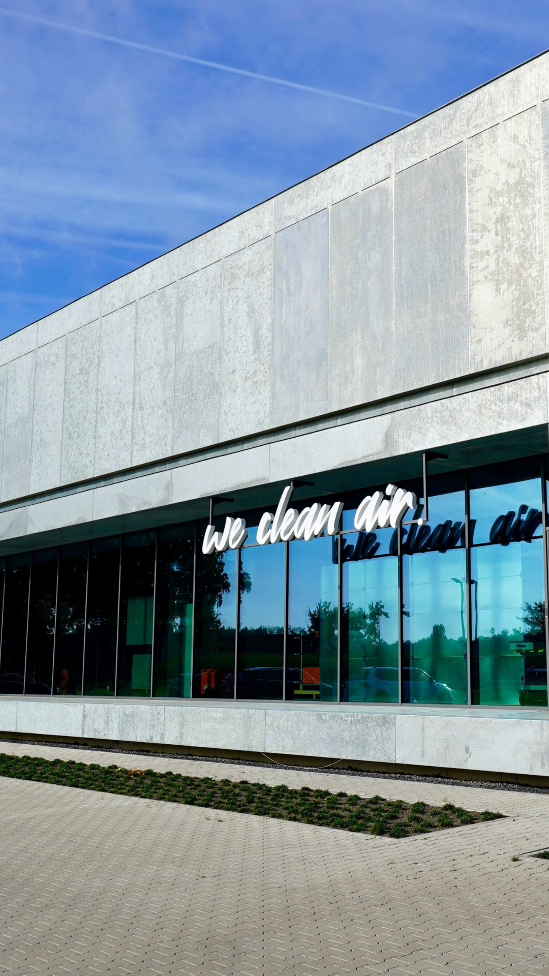 Modern building of KEMPER headquarters with glass facade and the “we clean air” slogan
