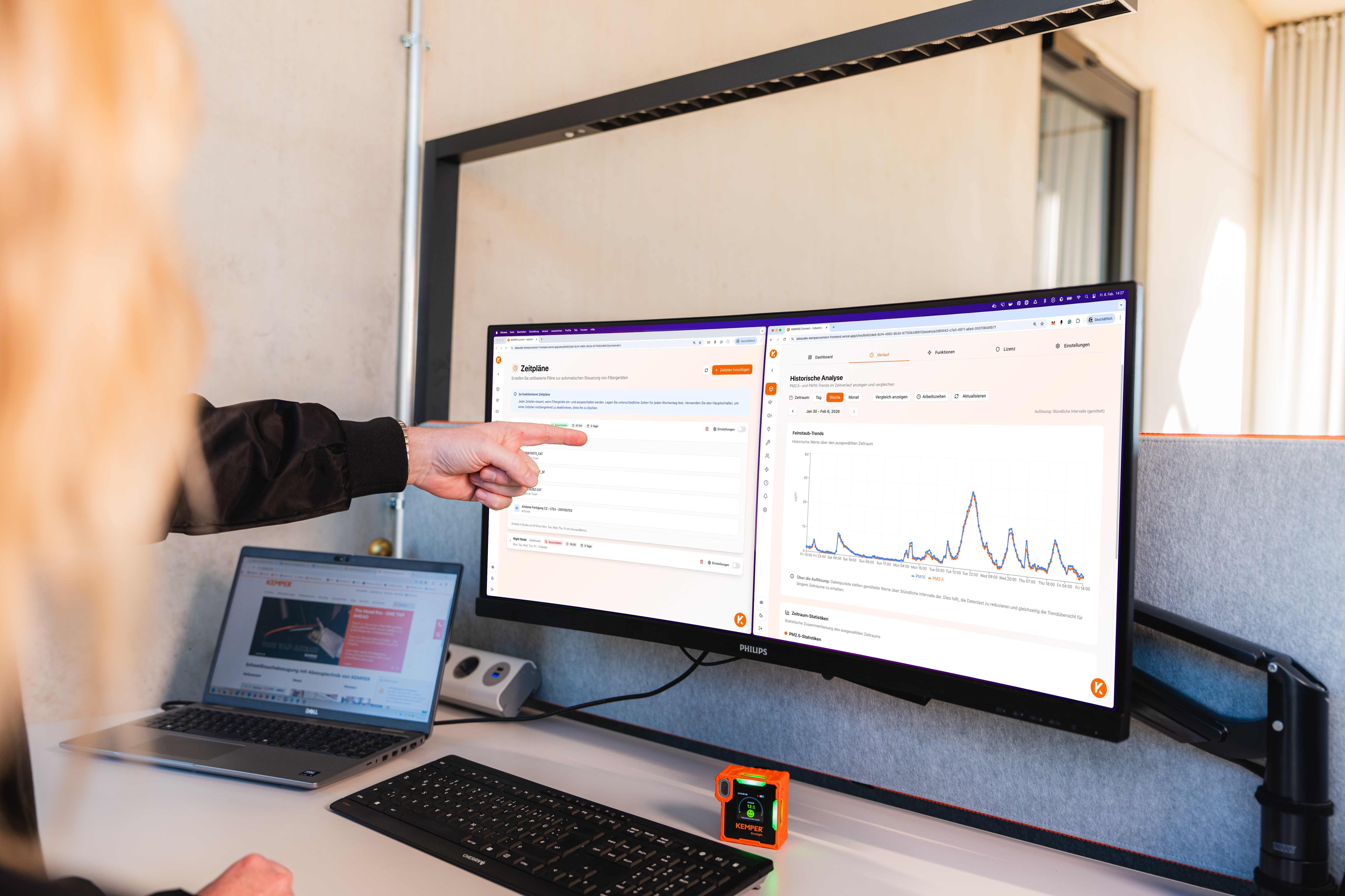 Puesto de trabajo con monitor y portátil que muestran la interfaz de KEMPER Connect con horarios y análisis histórico de un sistema de filtración de aire.