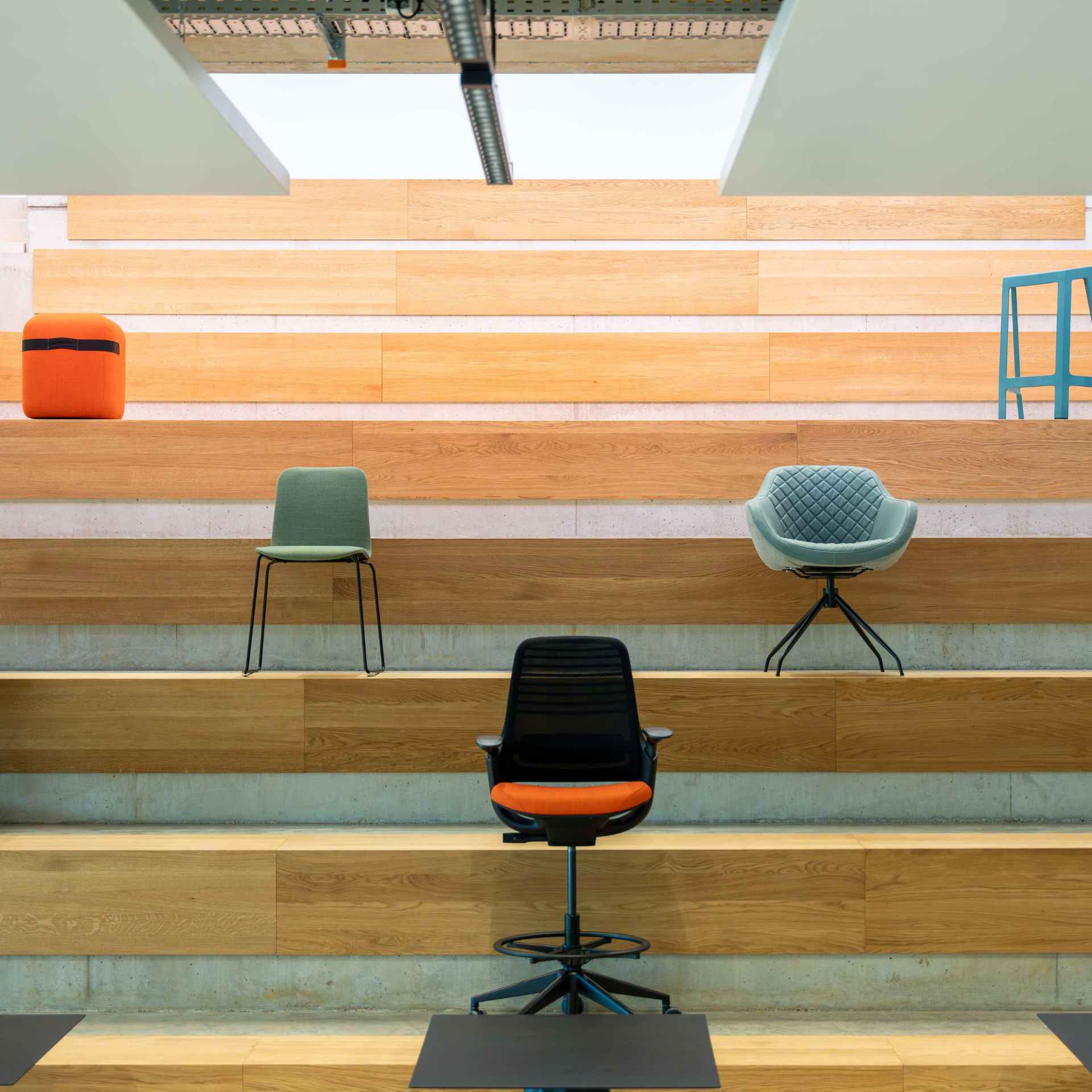 Modern stepped seating area with different chairs in an open office or presentation space