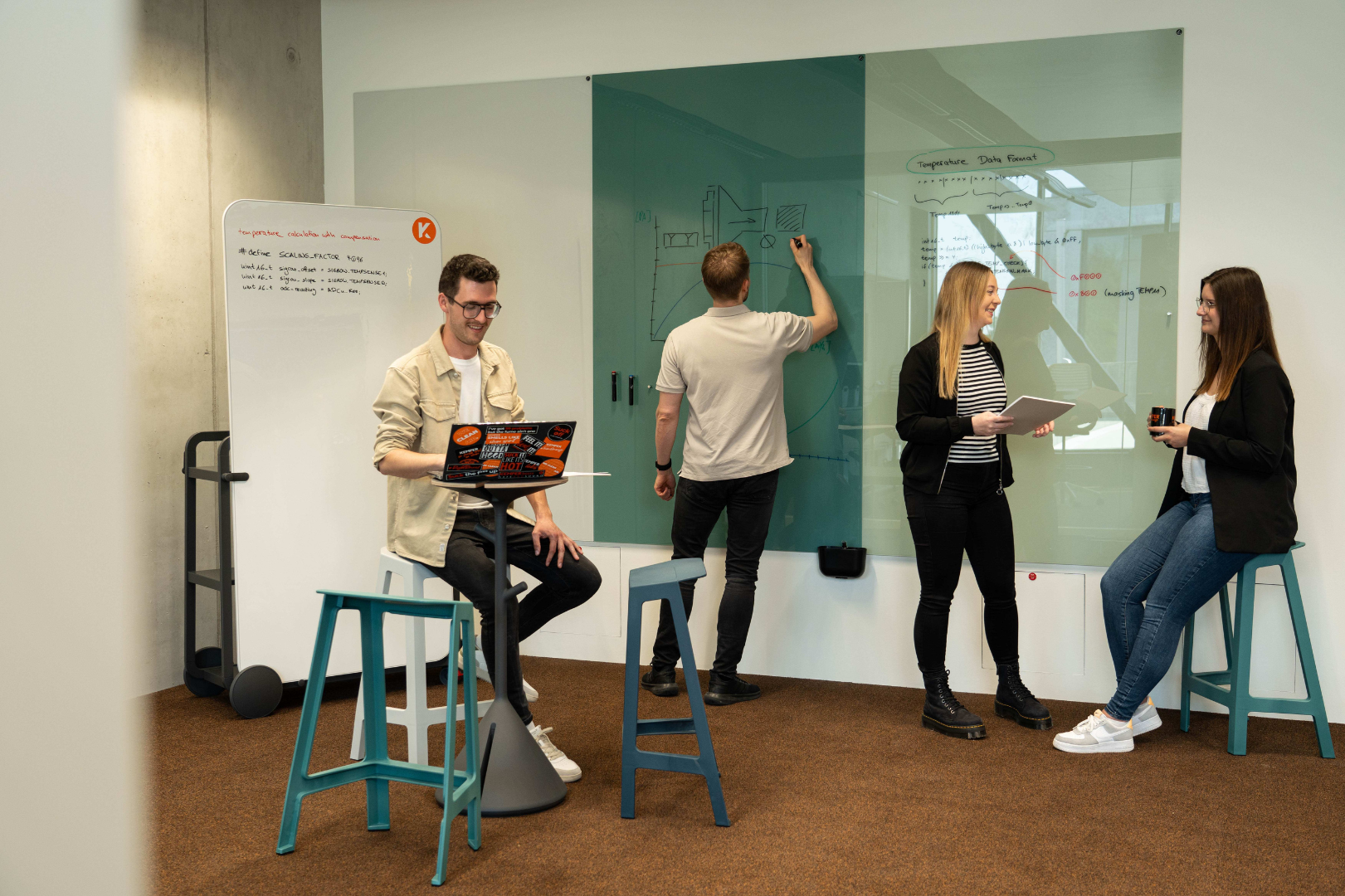 Employees at KEMPER collaborating on ideas and concepts in a modern office