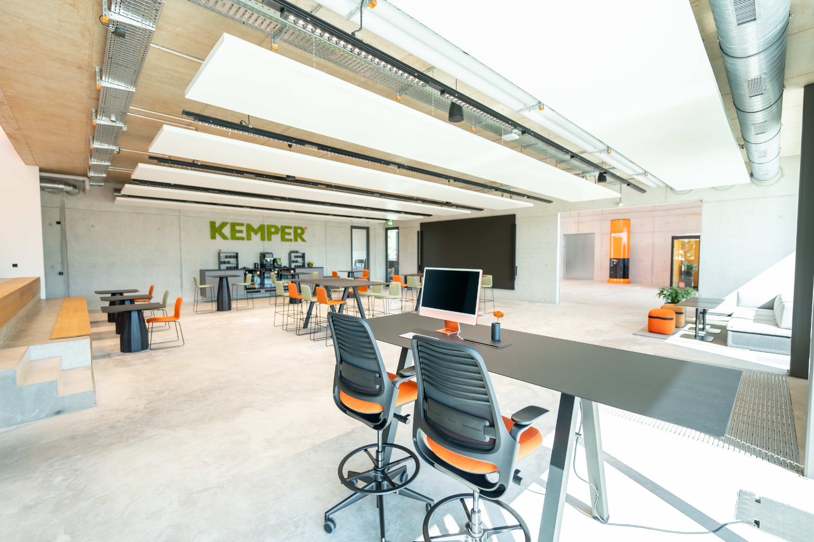 Large modern open workspace with desks, seating areas and meeting zones at KEMPER headquarters