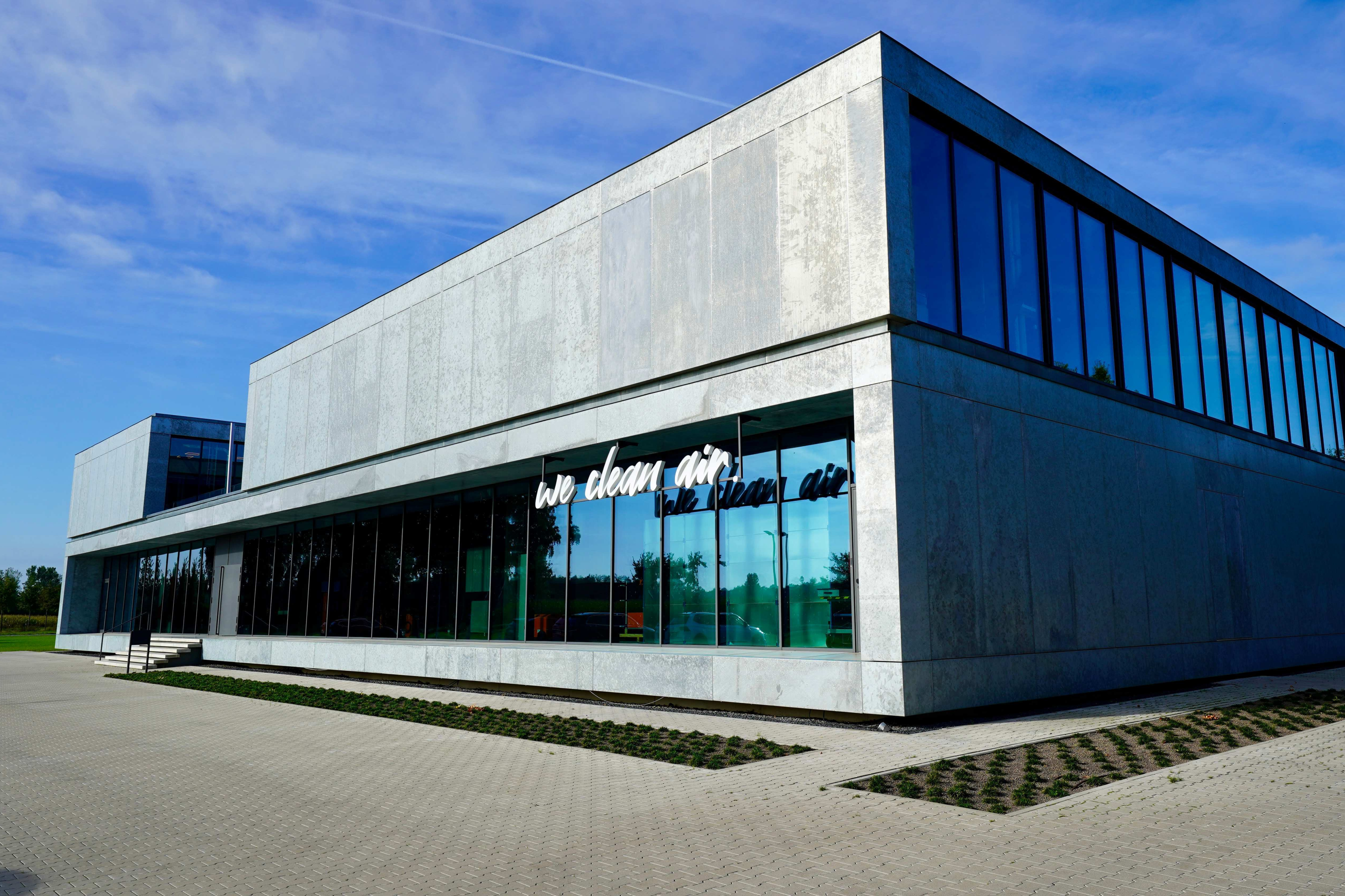 Modern KEMPER company building with glass facade and the slogan “we clean air”